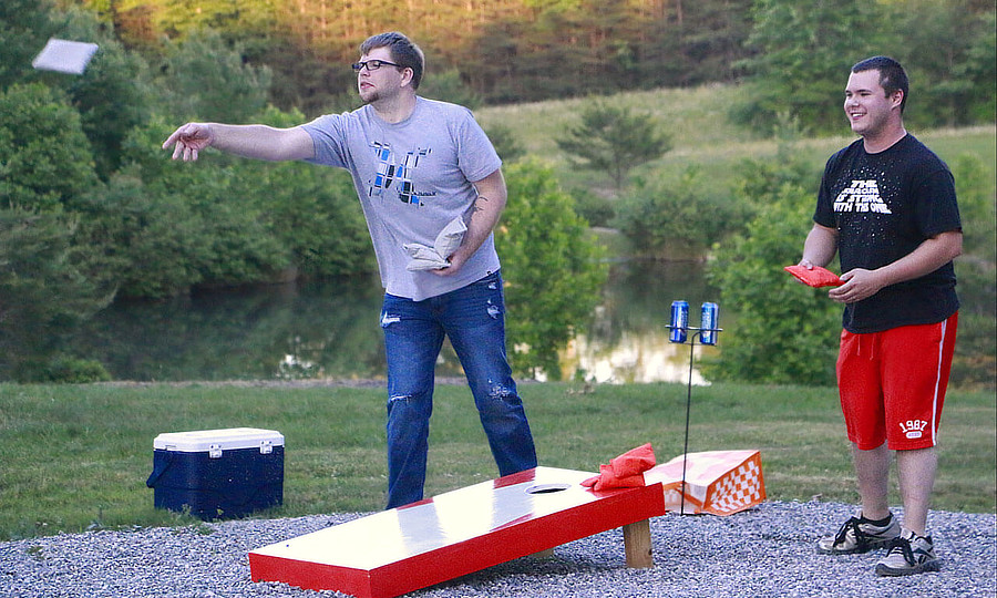 Kids playing corn hole toss game